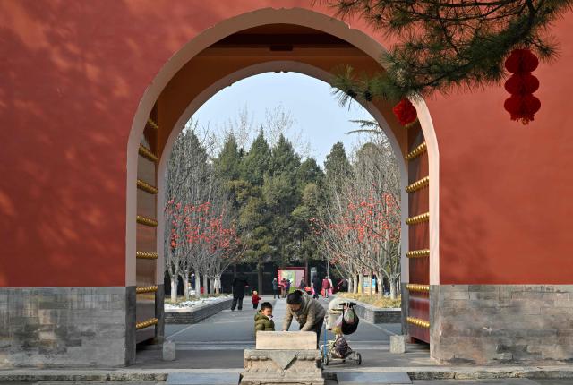 A woman and a child visit a park in Beijing on March 7, 2026. The world's second-most populous country is threatened with a demographic crisis after its birth rate halved over the past decade -- all while people rapidly age out of the workforce. (Photo by Adek BERRY / AFP) / TO GO WITH AFP STORY: China-economy-demographics-infants, by Mary YANG