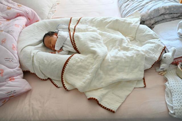 Newborn baby Zhu Wanning is pictured in Langfang, northern China's Hebei province on March 6, 2026. The world's second-most populous country is threatened with a demographic crisis after its birth rate halved over the past decade -- all while people rapidly age out of the workforce. (Photo by Adek BERRY / AFP) / TO GO WITH AFP STORY: China-economy-demographics-infants, by Mary YANG
