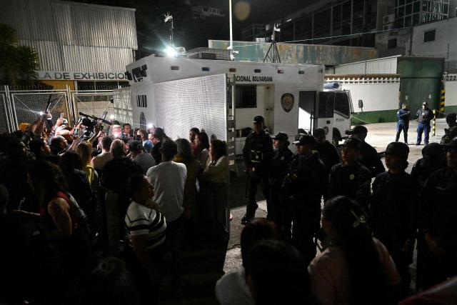 Venezuelan police officers stand guard during the release of prisoners at the entrance to the Bolivarian National Police (PNB) Zone 7 prison in Caracas on March 7, 2026. (Photo by Juan BARRETO / AFP)