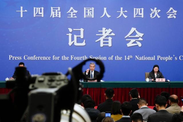 China's Foreign Minister Wang Yi (C), who is also a member of the Political Bureau of the Communist Party of China Central Committee, attends a press conference on the country's foreign policy and external relations for the fourth session of the 14th National People's Congress (NPC) in Beijing on March 8, 2026. (Photo by Iori Sagisawa / POOL / AFP)