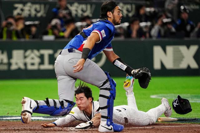 South Korea's Kim Hye-seong (bottom) scores as Kim Do-yeong (not pictured) hits a double during the World Baseball Classic (WBC) Pool C game between Taiwan and South Korea at the Tokyo Dome in Tokyo on March 8, 2026. (Photo by Yuichi YAMAZAKI / AFP)