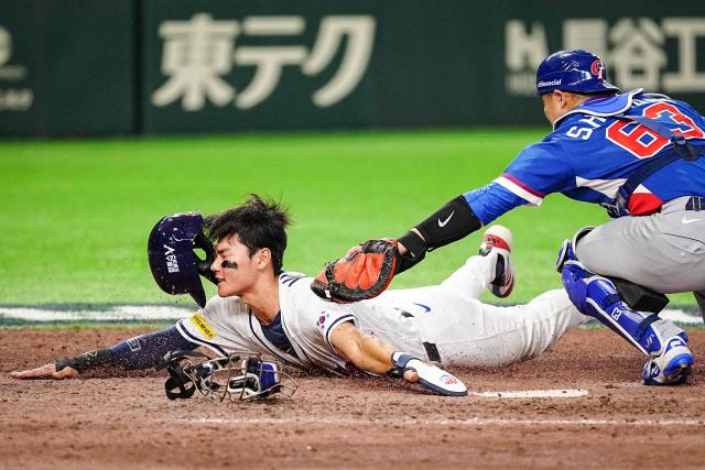 TOPSHOT - Taiwan's Shao-Hung Chiang (R) tags out South Korea's Kim Ju-won at home plate during the World Baseball Classic (WBC) Pool C game between Taiwan and South Korea at the Tokyo Dome in Tokyo on March 8, 2026. (Photo by Yuichi YAMAZAKI / AFP)