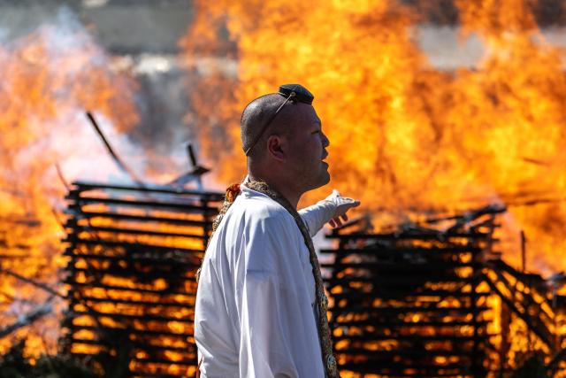 A buddhist monk walks past a burning sacred fire during the annual "Hiwatari Matsuri", known as fire walking festival, at the Takaosan Yakuoin Temple in Hachioji area, the western portion of the Tokyo Metropolis on March 8, 2026. (Photo by Philip FONG / AFP)