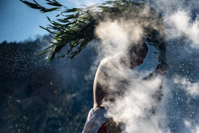A buddhist monk splashes hot water during the annual "Hiwatari Matsuri", known as fire walking festival, at the Takaosan Yakuoin Temple in Hachioji area, the western portion of the Tokyo Metropolis on March 8, 2026. (Photo by Philip FONG / AFP)