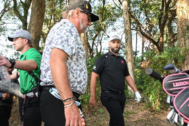LIV Golf team Legion XIII GC captain Jon Rahm (R) of Spain walks through after hitting a ball out of the rough on the 18th fairway on day four of the LIV Golf tournament at Fanling golf club in Hong Kong on March 8, 2026. (Photo by Peter PARKS / AFP)