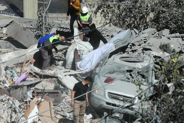 First aid responders inspect the site of an Israeli airstrike that targeted a neighborhood in the southern Lebanese village of Ghaziyeh on March 8, 2026. Lebanon was drawn into the Middle East war on March 2, when Iran-backed militant group Hezbollah attacked Israel in response to the killing of Iranian supreme leader Ayatollah Ali Khamenei during US-Israeli strikes. Israel, which has kept up strikes targeting Hezbollah despite a 2024 ceasefire, launched multiple waves of strikes this week across Lebanon and sent ground troops into border areas. (Photo by MAHMOUD ZAYYAT / AFP)