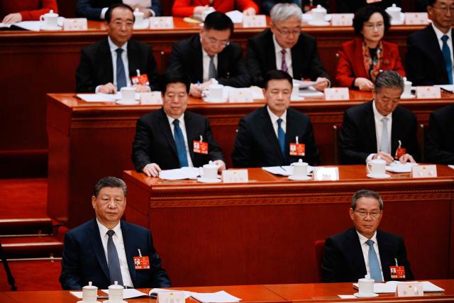 Chinese President Xi Jinping (L) and Premier Li Qiang (R) listen to a speech during a plenary session of China's National People's Congress in Beijing on March 9, 2026. (Photo by Vincent Thian / POOL / AFP)