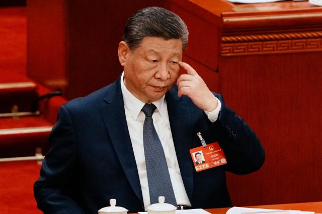 Chinese President Xi Jinping reacts as he listens to a speech during a plenary session of China's National People's Congress (NPC) at the Great Hall of the People in Beijing on March 9, 2026. (Photo by Vincent Thian / POOL / AFP)