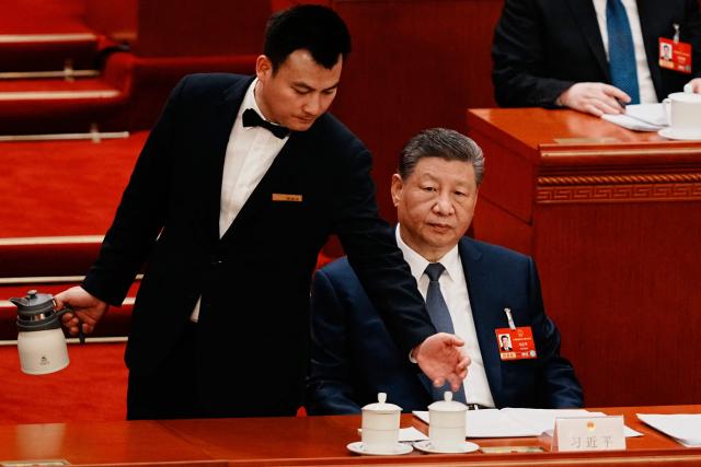 An attendant prepares tea for Chinese President Xi Jinping during a plenary session of China's National People's Congress in Beijing on March 9, 2026. (Photo by Vincent Thian / POOL / AFP)