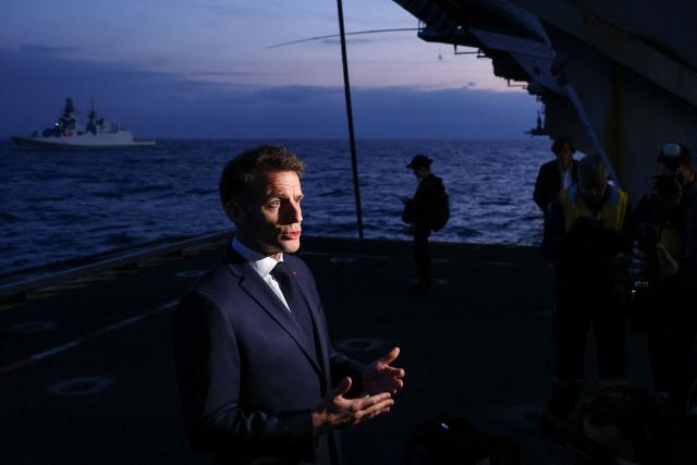 French President Emmanuel Macron addresses medias as he visits the French aircraft carrier Charles de Gaulle, deployed to the Mediterranean following Iranian drone strikes on Cyprus on the Mediterranean Sea, on March 9, 2026, on the sidelines of his trip to Cyprus to discuss regional security. (Photo by Gonzalo Fuentes / POOL / AFP)