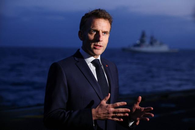 French President Emmanuel Macron addresses medias as he visits the French aircraft carrier Charles de Gaulle, deployed to the Mediterranean following Iranian drone strikes on Cyprus on the Mediterranean Sea, on March 9, 2026, on the sidelines of his trip to Cyprus to discuss regional security. (Photo by Gonzalo Fuentes / POOL / AFP)