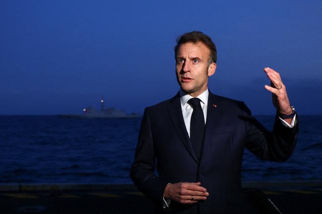 French President Emmanuel Macron addresses medias as he visits the French aircraft carrier Charles de Gaulle deployed in the Mediterranean Sea following Iranian drone strikes on Cyprus, on March 9, 2026, on the sidelines of his trip to Cyprus to discuss regional security. (Photo by Gonzalo Fuentes / POOL / AFP)