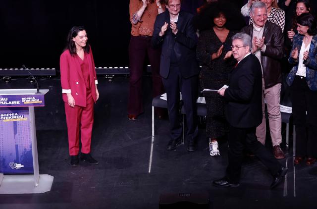 La France Insoumise's MP and head candidate in the Paris municipal elections Sophia Chikirou (L) welcomes Leader of French left-wing party Jean-Luc Melenchon (3R) at the end of her speech during a campaign rally of the left-wing lists candidates ahead of France's upcoming municipal elections at the Mutualite venue in Paris on March 9, 2026. (Photo by Kenzo TRIBOUILLARD / AFP)