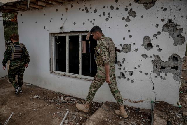 Kurdish fighters, members of The Organization of Iranian Kurdistan Struggle (Sazmani Khabat), walks past a damaged building after an Iranian drone attack to their base near Erbil, in Iraq's northern autonomous Kurdish region on March 9, 2026. Iran has designated Kurdish rebels groups as terrorist organisations, and many have previously fought its security forces in Kurdish-majority areas along the border. (Photo by Ozan KOSE / AFP) / Attention editors: AFP covers the war in the Middle East through its extensive regional network, including bureaus in Tehran, Jerusalem and several neighboring countries.Since the start of the conflict, journalists have been working under increasingly restrictive conditions. Authorities in several countries have limited reporters movements, photo and live video coverage from sensitive locations. Some governments and armed groups have banned images of missile or drone strikes and other security-related sites. / 