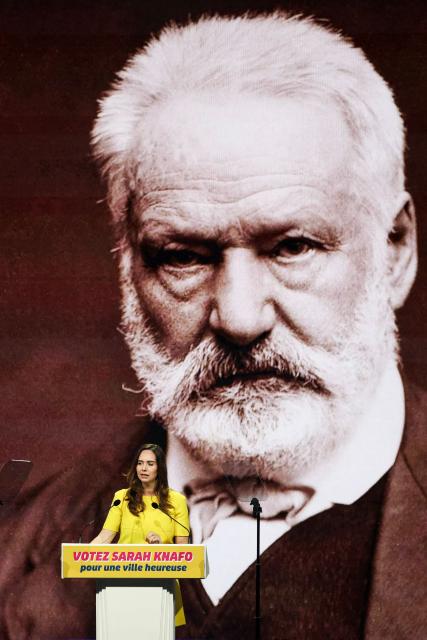 French far-right party Reconquete! MEP and candidate for mayor of Paris Sarah Knafo speaks in front of a giant screen displaying a portrait of French writer and politician Victor Hugo during a campaign meeting at the Dome de Paris venue in Paris on March 9, 2026. (Photo by Dimitar DILKOFF / AFP)