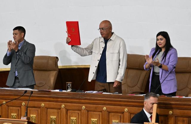 Venezuela's National Assembly President Jorge Rodriguez shows the new mining bill to be discussed at the National Assembly in Caracas on March 9, 2026. Venezuela begins debate on a new mining law on Marc 9, 2026, that seeks to attract foreign capital, amid renewed relations with the US following the fall of Nicolas Maduro. (Photo by Juan BARRETO / AFP)