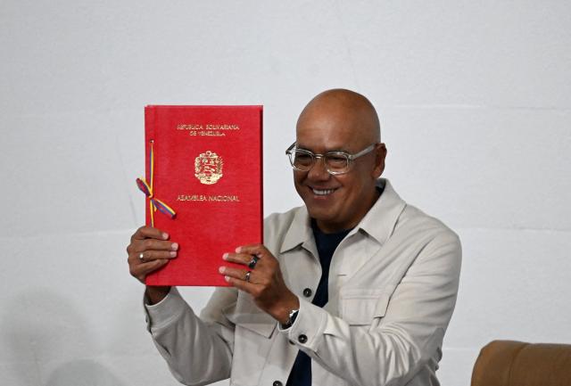 Venezuela's National Assembly President Jorge Rodriguez shows the new mining bill to be discussed at the National Assembly in Caracas on March 9, 2026. Venezuela begins debate on a new mining law on Marc 9, 2026, that seeks to attract foreign capital, amid renewed relations with the US following the fall of Nicolas Maduro. (Photo by Juan BARRETO / AFP)