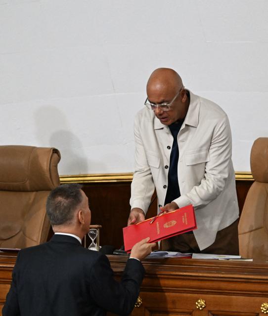 Venezuela's National Assembly President Jorge Rodriguez receives the new mining bill to be discussed at the National Assembly in Caracas on March 9, 2026. Venezuela begins debate on a new mining law on Marc 9, 2026, that seeks to attract foreign capital, amid renewed relations with the US following the fall of Nicolas Maduro. (Photo by Juan BARRETO / AFP)