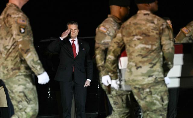 US Secretary of Defense Pete Hegseth salutes as members of a US Army team carry a flagged-drapped transfer case containing the remains of Sgt. Benjamin N. Pennington, 26, of Glendale, Kentucky, during a dignified transfer solemn event at Dover Air Force Base, in Dover, Delaware, on March 9, 2026. (Photo by Brendan SMIALOWSKI / AFP)