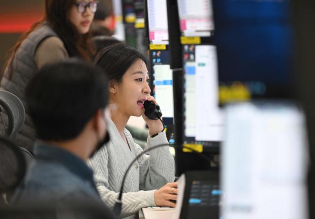 A currency dealer speaks over a phone as she monitors exchange rates in a foreign exchange dealing room at the Hana Bank headquarters in Seoul on March 10, 2026. Stock markets in South Korea and Japan rose sharply in early trade on March 10, after the US crude oil benchmark, WTI, fell more than six percent. (Photo by Jung Yeon-je / AFP)