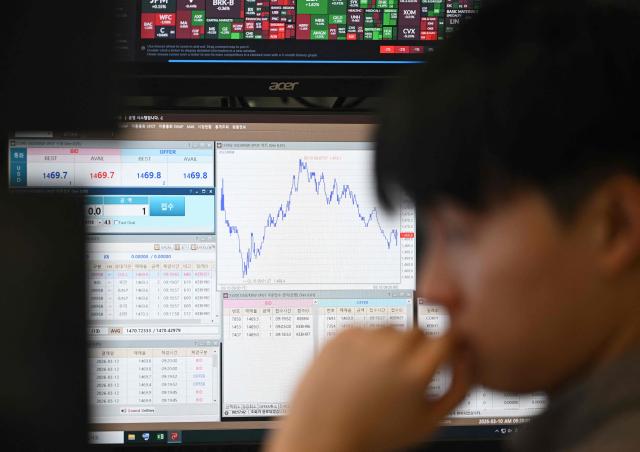 A currency dealer monitors exchange rates in a foreign exchange dealing room at the Hana Bank headquarters in Seoul on March 10, 2026. Stock markets in South Korea and Japan rose sharply in early trade on March 10, after the US crude oil benchmark, WTI, fell more than six percent. (Photo by Jung Yeon-je / AFP)