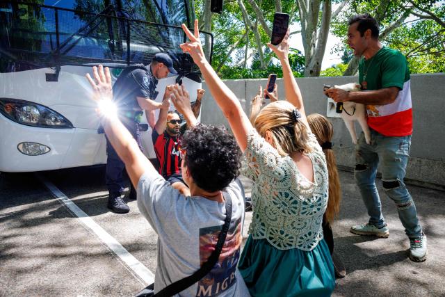 Members of the Iranian community in Australia block the path of a departing bus transporting members of the Iranian Women’s Asia Cup football team to the airport, outside the Royal Pines Resort on the Gold Coast on March 10, 2026. Five players from Iran's visting women's football team claimed asylum in Australia on March 10, seeking protection after they were branded "traitors" at home for refusing to sing the national anthem. (Photo by Patrick HAMILTON / AFP)