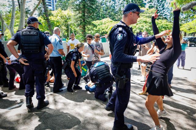 Police officers react as members of the Iranian community in Australia block the path of a departing bus transporting members of the Iranian Women’s Asia Cup football team to the airport, outside the Royal Pines Resort on the Gold Coast on March 10, 2026. Five players from Iran's visting women's football team claimed asylum in Australia on March 10, seeking protection after they were branded "traitors" at home for refusing to sing the national anthem. (Photo by Patrick HAMILTON / AFP)