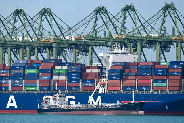 An oil tanker refuels a container vessel docked at Pasir Panjang port terminal in Singapore on March 10, 2026. (Photo by Roslan RAHMAN / AFP)