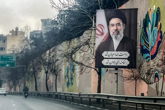 TOPSHOT - A banner depicting Iran's new Supreme Leader Ayatollah Mojtaba Khamenei is displayed on the side of a highway in Tehran on March 10, 2026. Iran marked the appointment of Ayatollah Mojtaba Khamenei to replace his father as its supreme leader on March 9 with a new barrage of missiles against Israel and the Gulf states on Monday, as the Middle East war sent oil prices soaring. (Photo by AFP) / Attention editors: AFP covers the war in the Middle East through its extensive regional network, including bureaus in Tehran, Jerusalem and several neighboring countries.Since the start of the conflict, journalists have been working under increasingly restrictive conditions. Authorities in several countries have limited reportersâ€™ movements, photo and live video coverage from sensitive locations. Some governments and armed groups have banned images of missile or drone strikes and other security-related sites. / 