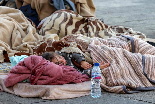 TOPSHOT - A child sleeps alongside family belongings in a makeshift encampment along the waterfront in Beirut on March 10, 2026, as civilians who fled the city's southern suburbs due to Israeli bombardment remain displaced. Lebanese authorities said on March 9 that Israel's attacks since March 2 have killed at least 486 people and wounded at least 1,313, with more than 660,000 registered as displaced and 120,000 sleeping at official shelters. Lebanon was drawn into the Middle East war when Iran-backed Hezbollah attacked Israel, in response to the killing of the Iranian supreme leader in US-Israeli strikes on February 28. (Photo by Anwar AMRO / AFP) / Attention editors: AFP covers the war in the Middle East through its extensive regional network, including bureaus in Tehran, Jerusalem and several neighboring countries.Since the start of the conflict, journalists have been working under increasingly restrictive conditions. Authorities in several countries have limited reporters movements, photo and live video coverage from sensitive locations. Some governments and armed groups have banned images of missile or drone strikes and other security-related sites. / 