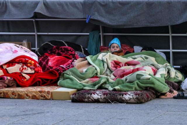 A boy looks on while lying under a blanket alongside family belongings in a makeshift encampment along the waterfront in Beirut on March 10, 2026, as civilians who fled the city's southern suburbs due to Israeli bombardment remain displaced. Lebanese authorities said on March 9 that Israel's attacks since March 2 have killed at least 486 people and wounded at least 1,313, with more than 660,000 registered as displaced and 120,000 sleeping at official shelters. Lebanon was drawn into the Middle East war when Iran-backed Hezbollah attacked Israel, in response to the killing of the Iranian supreme leader in US-Israeli strikes on February 28. (Photo by Anwar AMRO / AFP) / Attention editors: AFP covers the war in the Middle East through its extensive regional network, including bureaus in Tehran, Jerusalem and several neighboring countries.Since the start of the conflict, journalists have been working under increasingly restrictive conditions. Authorities in several countries have limited reporters movements, photo and live video coverage from sensitive locations. Some governments and armed groups have banned images of missile or drone strikes and other security-related sites. / 