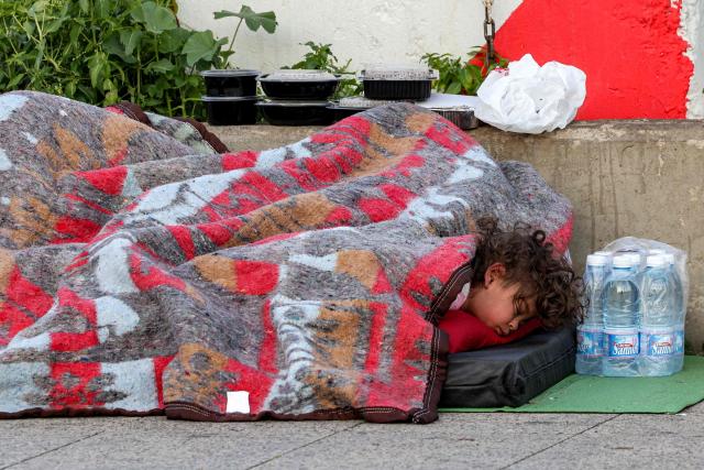 TOPSHOT - A child sleeps alongside family belongings in a makeshift encampment along the waterfront in Beirut on March 10, 2026, as civilians who fled the city's southern suburbs due to Israeli bombardment remain displaced. Lebanese authorities said on March 9 that Israel's attacks since March 2 have killed at least 486 people and wounded at least 1,313, with more than 660,000 registered as displaced and 120,000 sleeping at official shelters. Lebanon was drawn into the Middle East war when Iran-backed Hezbollah attacked Israel, in response to the killing of the Iranian supreme leader in US-Israeli strikes on February 28. (Photo by Anwar AMRO / AFP) / Attention editors: AFP covers the war in the Middle East through its extensive regional network, including bureaus in Tehran, Jerusalem and several neighboring countries.Since the start of the conflict, journalists have been working under increasingly restrictive conditions. Authorities in several countries have limited reporters movements, photo and live video coverage from sensitive locations. Some governments and armed groups have banned images of missile or drone strikes and other security-related sites. / 