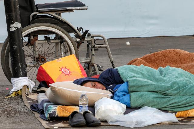 A person sleeps alongside family belongings in a makeshift encampment along the waterfront in Beirut on March 10, 2026, as civilians who fled the city's southern suburbs due to Israeli bombardment remain displaced. Lebanese authorities said on March 9 that Israel's attacks since March 2 have killed at least 486 people and wounded at least 1,313, with more than 660,000 registered as displaced and 120,000 sleeping at official shelters. Lebanon was drawn into the Middle East war when Iran-backed Hezbollah attacked Israel, in response to the killing of the Iranian supreme leader in US-Israeli strikes on February 28. (Photo by Anwar AMRO / AFP) / Attention editors: AFP covers the war in the Middle East through its extensive regional network, including bureaus in Tehran, Jerusalem and several neighboring countries.Since the start of the conflict, journalists have been working under increasingly restrictive conditions. Authorities in several countries have limited reporters movements, photo and live video coverage from sensitive locations. Some governments and armed groups have banned images of missile or drone strikes and other security-related sites. / 