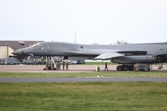 Military personnel gather next to a US Air Force B-1 Lancer bomber parked on the tarmac at RAF Fairford in south-west England on March 10, 2026. Fairford is one of two bases, along with the Diego Garcia facility in the Indian Ocean, that the UK has given the US permission to use for "specific defensive operations into Iran" to destroy Iranian missiles at source, the British defence minister said in a statement. (Photo by Henry NICHOLLS / AFP)