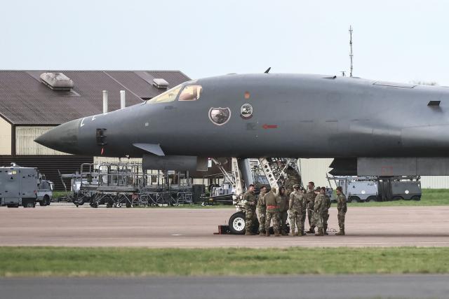 Military personnel gather next to a US Air Force B-1 Lancer bomber parked on the tarmac at RAF Fairford in south-west England on March 10, 2026. Fairford is one of two bases, along with the Diego Garcia facility in the Indian Ocean, that the UK has given the US permission to use for "specific defensive operations into Iran" to destroy Iranian missiles at source, the British defence minister said in a statement. (Photo by Henry NICHOLLS / AFP)