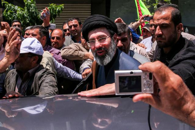 (FILES) In this picture obtained from Iran's ISNA news agency, Mojtaba Khamenei, son of Iran's supreme leader Ayatollah Ali Khamenei (C), is greeted by people in Tehran on May 31, 2019. Iran marked the appointment of Ayatollah Mojtaba Khamenei to replace his father as its supreme leader with a new barrage of missiles against Israel and the Gulf states on March 9, 2026, as the Middle East war sent oil prices soaring. (Photo by ALI TAGHAVI / ISNA / AFP)