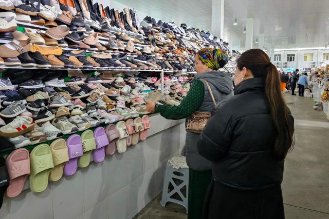 A woman examines Iranian made footwear at a market in the Turkmen capital of Ashgabat on March 9, 2026. (Photo by AFP)