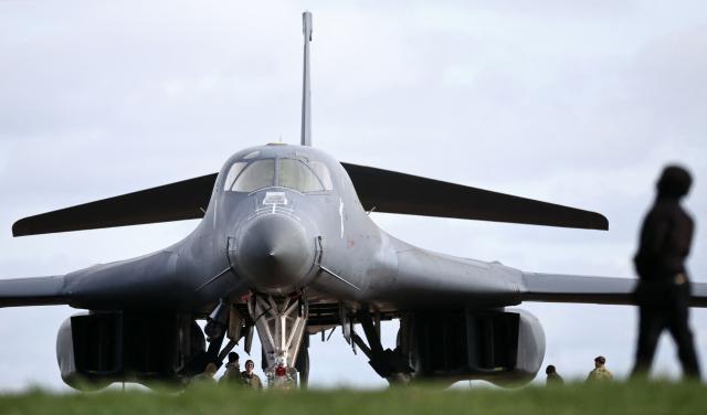 Members of the US Air Force (USAF) work on a USAF B-1 Lancer bomber parked on the tarmac at RAF Fairford in south-west England on March 10, 2026. Fairford is one of two bases, along with the Diego Garcia facility in the Indian Ocean, that the UK has given the US permission to use for "specific defensive operations into Iran" to destroy Iranian missiles at source, the British defence minister said in a statement. (Photo by Henry NICHOLLS / AFP)