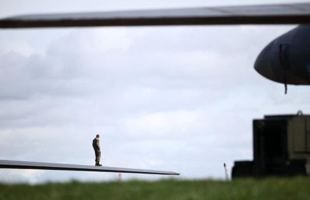 Members of the US Air Force (USAF) work on a USAF B-1 Lancer bomber jet parked on the tarmac at RAF Fairford in south-west England on March 10, 2026. Fairford is one of two bases, along with the Diego Garcia facility in the Indian Ocean, that the UK has given the US permission to use for "specific defensive operations into Iran" to destroy Iranian missiles at source, the British defence minister said in a statement. (Photo by Henry NICHOLLS / AFP)