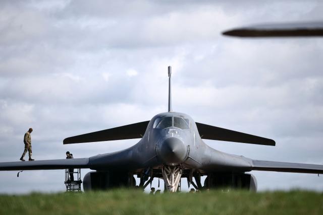 Members of the US Air Force (USAF) work on a USAF B-1 Lancer bomber jet parked on the tarmac at RAF Fairford in south-west England on March 10, 2026. Fairford is one of two bases, along with the Diego Garcia facility in the Indian Ocean, that the UK has given the US permission to use for "specific defensive operations into Iran" to destroy Iranian missiles at source, the British defence minister said in a statement. (Photo by Henry NICHOLLS / AFP)