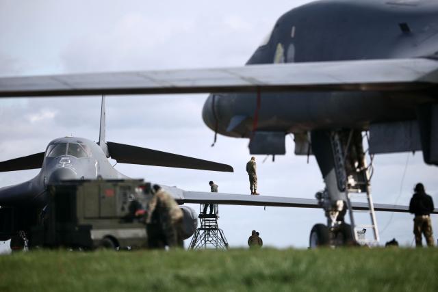 Members of the US Air Force (USAF) work on USAF B-1 Lancer bomber jets parked on the tarmac at RAF Fairford in south-west England on March 10, 2026. Fairford is one of two bases, along with the Diego Garcia facility in the Indian Ocean, that the UK has given the US permission to use for "specific defensive operations into Iran" to destroy Iranian missiles at source, the British defence minister said in a statement. (Photo by Henry NICHOLLS / AFP)
