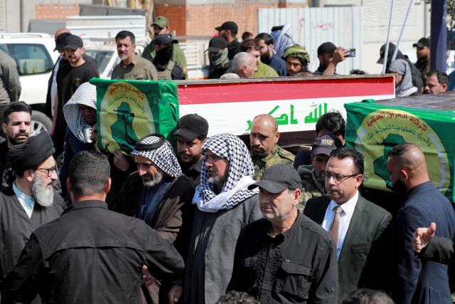 Mourners carry one of the caskets of members of Iraq's Hashed al-Shaabi, or the Popular Mobilisation Forces (PMF) -- an alliance of factions now integrated into the regular army that also includes powerful Iran-backed groups -- who were killed in reported strikes on Kirkuk, during the funeral in Baghdad on March 10, 2026. Since the start of the Middle East war, bases belonging to Hashed al-Shaabi, or the Popular Mobilisation Forces, have been hit several times. Iraq, long a proxy battleground between the US and Iran, had said it did not want to be dragged into the war, but it has not been spared. (Photo by Murtaja LATEEF / AFP)