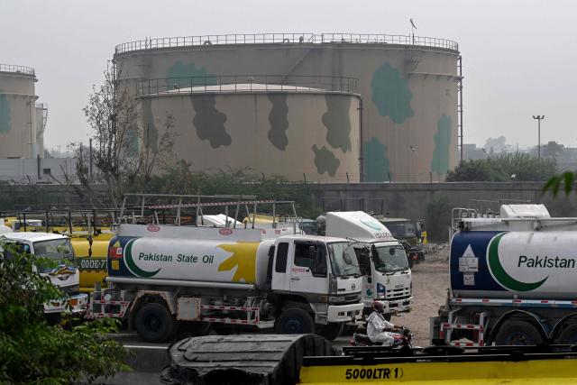 Pakistan State Oil tankers line up along a road before entering a fuel storage facility in Sheikhupura district in Lahore on March 10, 2026. Pakistan's Prime Minister Shehbaz Sharif on March 9 unveiled a raft of austerity measures designed to save fuel, as oil prices soar due to the US-Israeli war on Iran. (Photo by Arif ALI / AFP)