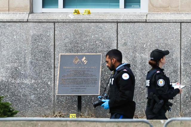 Toronto Police officers work around the scene of a shooting at the US Consulate in Toronto, Canada, on March 10, 2026. Shots were fired at the US consulate in Toronto early Tuesday but no one was injured, police said, days after Middle East war protests outside the building. The Toronto Police Service said it received reports of a firearm being discharged at the consulate before dawn in the downtown area of Canada's largest city. (Photo by Cole BURSTON / AFP)
