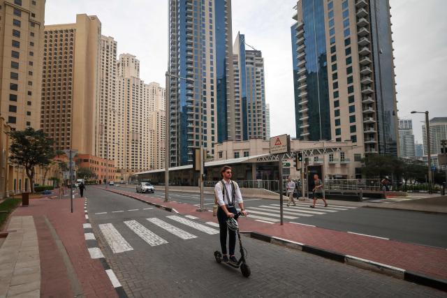 A man rides a scooter along a street in Dubai's Jumeirah Beach Residence (JBR) on March 10, 2026. The Gulf countries have long been seen as islands of stability in the Middle East, but the war in the region could threaten their prosperity, analysts said, pointing to risks to their revenues and reputations as business havens. (Photo by FADEL SENNA / AFP) / Attention editors: AFP covers the war in the Middle East through its extensive regional network, including bureaus in Tehran, Jerusalem, and several neighboring countries. Since the start of the conflict, journalists have been working under increasingly restrictive conditions. Authorities in several countries have limited reporters' movements, photo and live video coverage from sensitive locations. Some governments and armed groups have banned images of missile or drone strikes and other security-related sites. / 