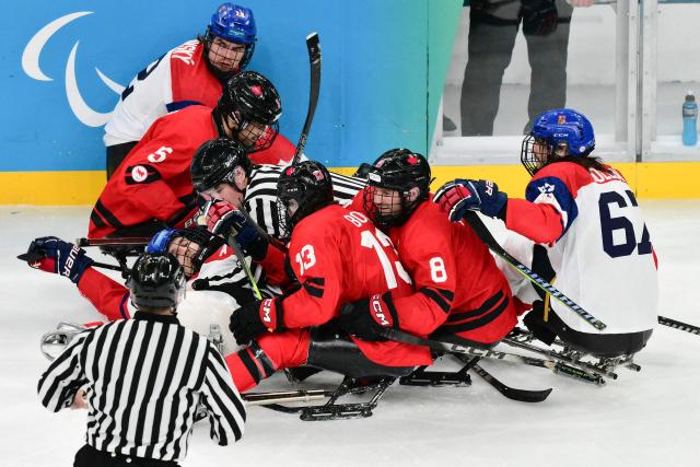 Czech Republic's Vaclav Hecko is blocked by a referee as he reacts during the ice hockey match between Czech Republic and Canada at the Milano Cortina 2026 Paralympic Winter Games in Milan on March 10, 2026. (Photo by Stefano RELLANDINI / AFP)