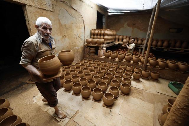 Artisans work on traditional pottery in a factory in Rabat on March 10, 2026. (Photo by Abdel Majid BZIOUAT / AFP)