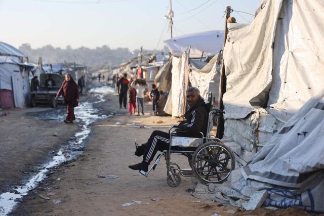 A displaced Palestinian man sits on a wheelchair next to a tent at the Jabalia refugee camp in the northern Gaza Strip on March 10, 2026. The majority of Gaza's 2.4 million people have been displaced, often multiple times, by the war that began with Hamas's attack on southern Israel on October 7, 2023. With displaced families living in tented camps, a serious concerns has been raised over their living conditions. (Photo by Omar AL-QATTAA / AFP)