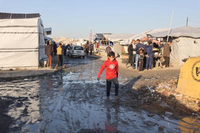 A displaced Palestinian boy walks in a muddy street at the Jabalia refugee camp in the northern Gaza Strip on March 10, 2026. The majority of Gaza's 2.4 million people have been displaced, often multiple times, by the war that began with Hamas's attack on southern Israel on October 7, 2023. With displaced families living in tented camps, a serious concerns has been raised over their living conditions. (Photo by Omar AL-QATTAA / AFP)
