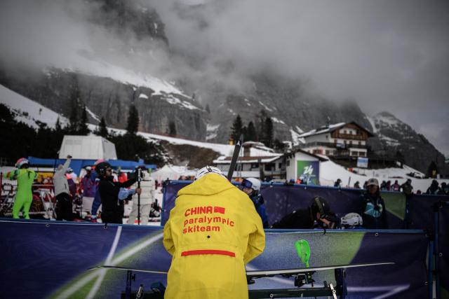 A skiman for the Chinese team prepares skis for the alpine skiing combined event during the Milano Cortina 2026 Paralympic Winter Games in Cortina d’Ampezzo on March 10, 2026. (Photo by JEFF PACHOUD / AFP)